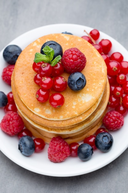 Pilha de panquecas com mirtilo e frutas frescas.