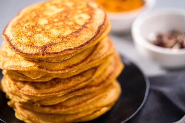 Pilha de panquecas de abóbora frescas em uma placa preta