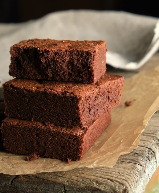 Pilha de pedaços quadrados assados de bolo brownie de chocolate