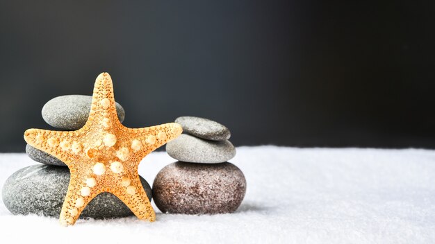 Pilha de pedras com estrela do mar, equilíbrio, pirâmide de pedras para meditação, pilha de pedras zen