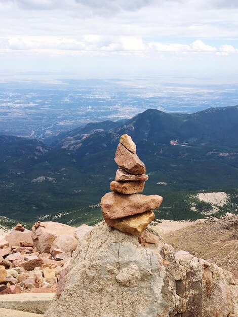 Foto pilha de pedras no topo da montanha contra o céu nublado