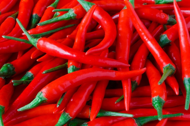 Pilha de pimentas vermelhas frescas sobre fundo vermelho