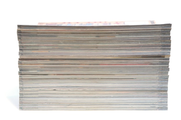 Pilha de revistas e jornais em um fundo branco.