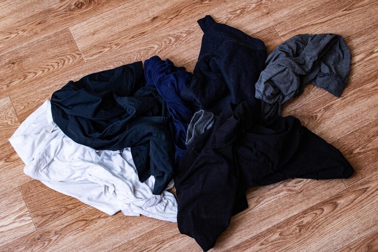 Pilha de roupas sujas no chão de madeira