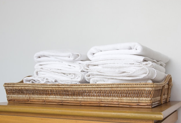 Pilha de toalha branca na cesta