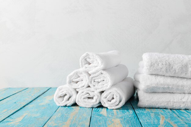 Foto pilha de toalhas de banho na mesa de madeira