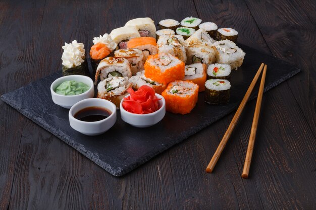Pilha de vários tipos de sushi servido na pedra preta