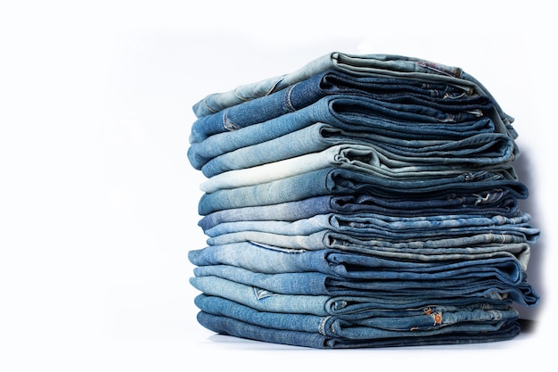 Pilha de vários tons de jeans azuis Jeans empilhados isolados no fundo branco Banner de textura de jeans azul com espaço de cópia para fundo de design de texto Canvas denim moda textura