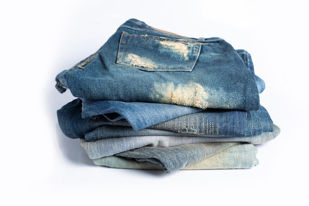 Pilha de vários tons de jeans azuis Jeans empilhados isolados no fundo branco Banner de textura de jeans azul com espaço de cópia para fundo de design de texto Canvas denim moda textura