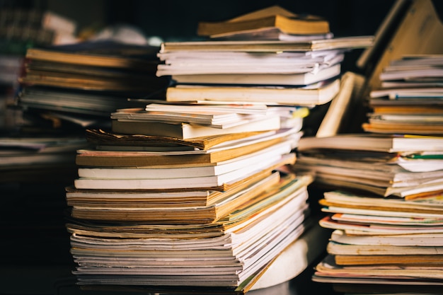 Pilha de velhos livros na mesa de madeira.