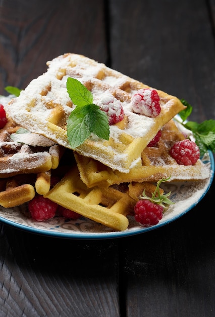 Pilha de waffles belgas assados com framboesa vermelha madura polvilhada com café da manhã de açúcar em pó