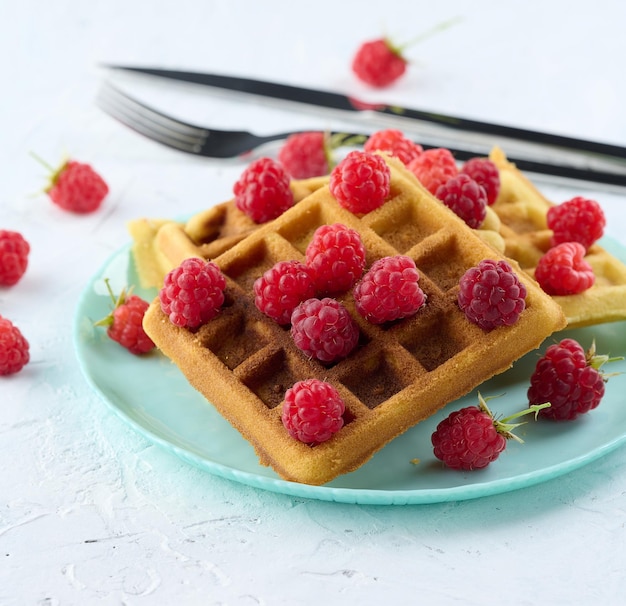 Pilha de waffles belgas assados com framboesa vermelha madura