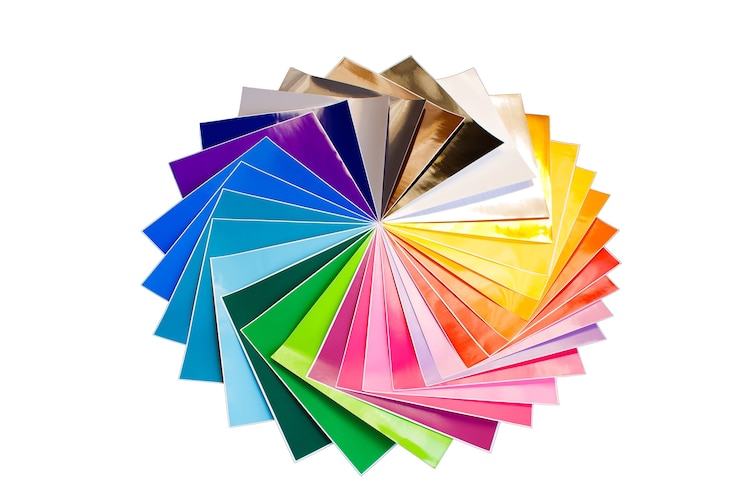 Foto pilha retorcida de folhas coloridas 12x12 de papel adesivo isoladas sobre o fundo branco. cores sortidas.