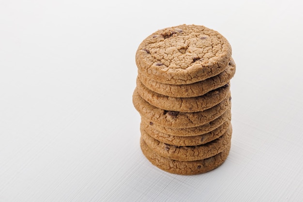 Pilha vertical de biscoitos de bolo redondo com chocolate no fundo da superfície branca