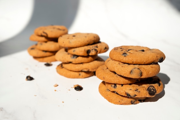 Pilhas de biscoitos de chocolate com pedaços de chocolate no fundo de mármore