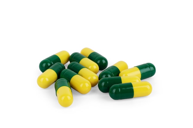 Pilhas de comprimidos e cápsulas em fundo branco, isoladas