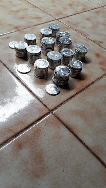 Pilhas de moedas de 100 e 200 rupias da República da Indonésia