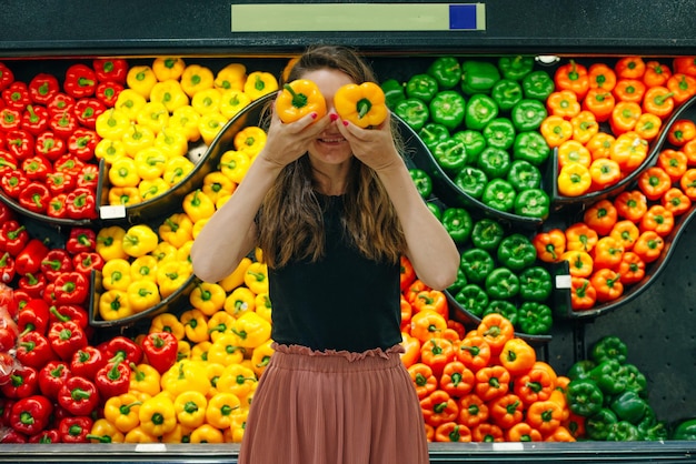 Pilhas de pimentão organizadas no balcão de um supermercado ou mercearia Pimentões verdes laranja e amarelos para venda