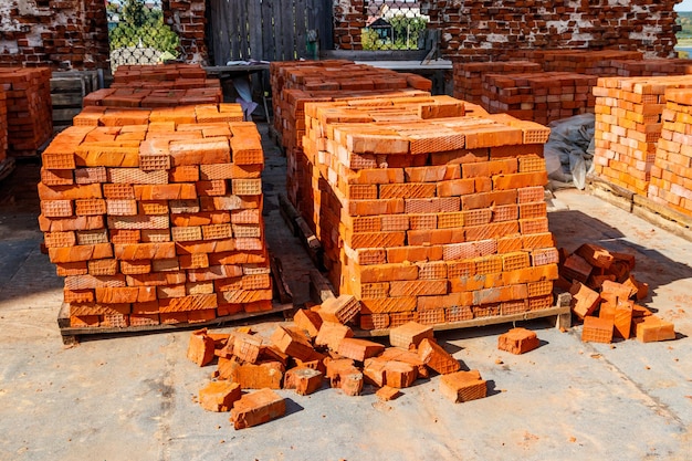 Pilhas de tijolo vermelho novo no canteiro de obras