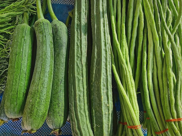 Pilhas de vegetais verdes frescos à venda na barraca do mercado