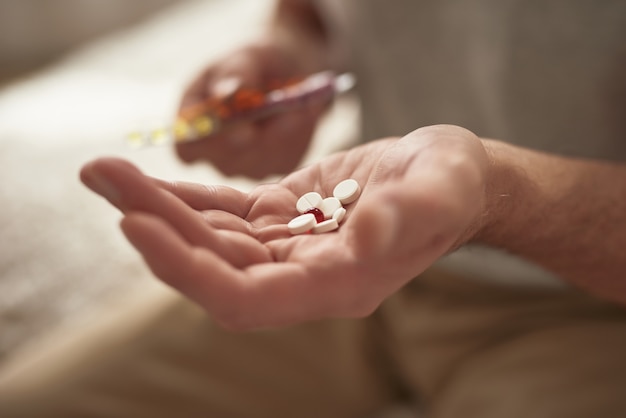 Pillen in der Hand des Rentners Man Holding Medicine.