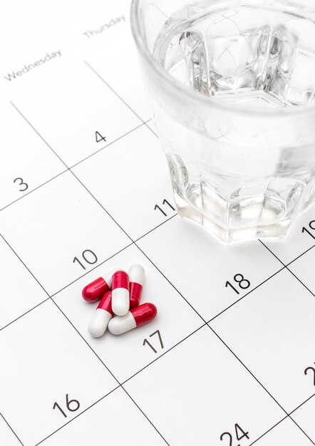 Pillen mit Glas Wasser im Kalender