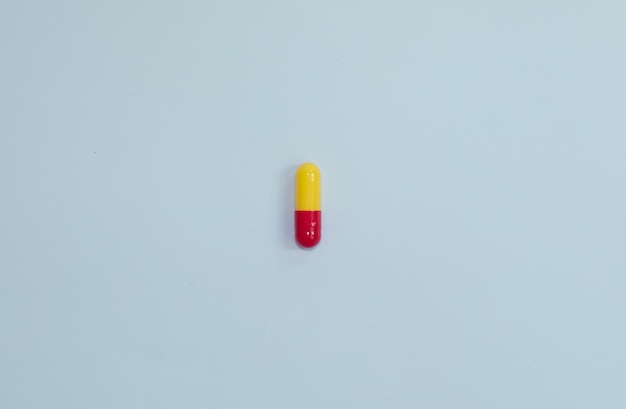 Pillen, Tabletten und Kapseln der pharmazeutischen Medizin auf blauem Hintergrund.