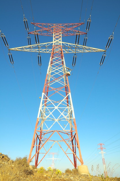 Pilón de la línea de energía eléctrica sobre una puesta de sol coloreada