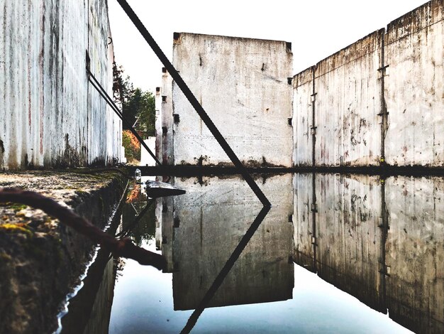 Foto pilote de madera en la pared junto al lago contra el cielo