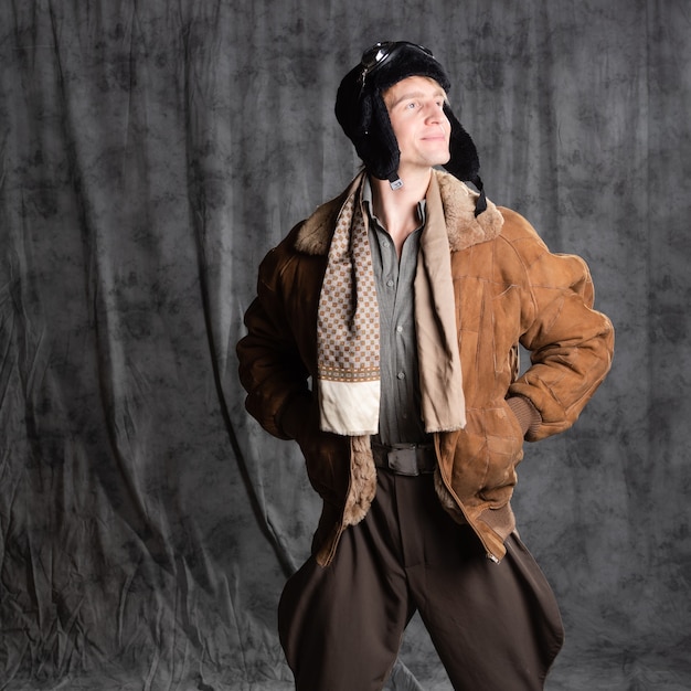 Piloto aviador en estilo retro un joven con una chaqueta de vuelo y gafas