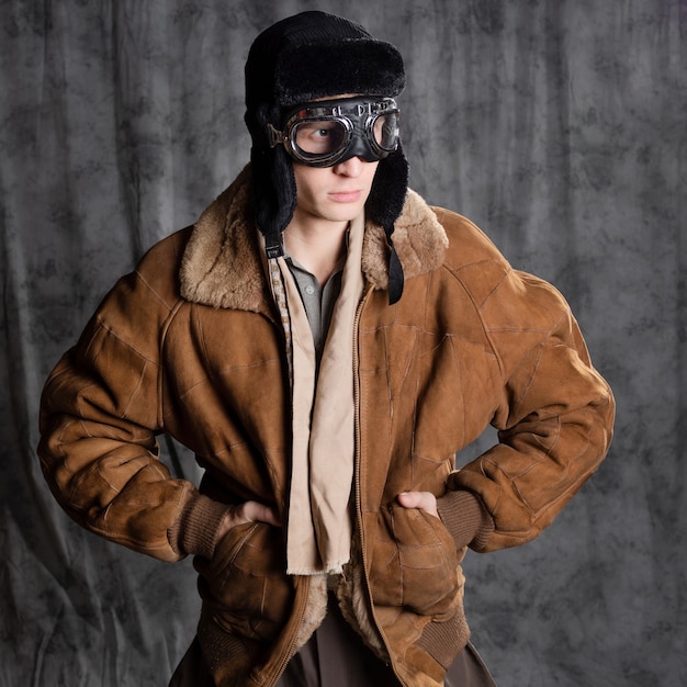 Piloto aviador en estilo retro un joven con una chaqueta de vuelo y gafas