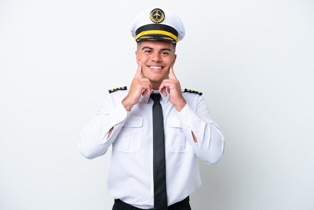 Piloto de avión hombre caucásico aislado de fondo blanco sonriendo con una expresión feliz y agradable