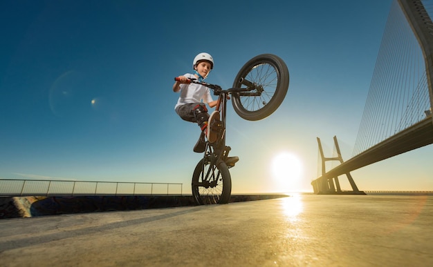 Un piloto de carreras de bmx adolescente realiza trucos en un parque de patinaje en una pista de bombeo