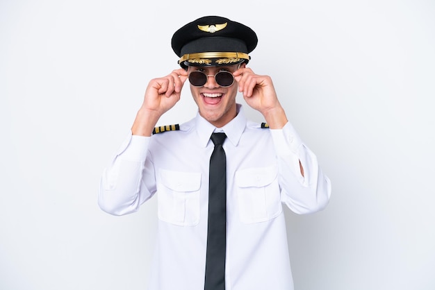 Piloto caucasiano de avião isolado no fundo branco com óculos e surpreso
