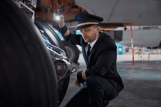 El piloto confiado de Profesol está comprobando el avión en el hangar