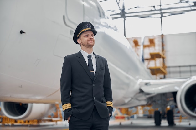 El piloto confiado de Profesol está comprobando el avión en el hangar