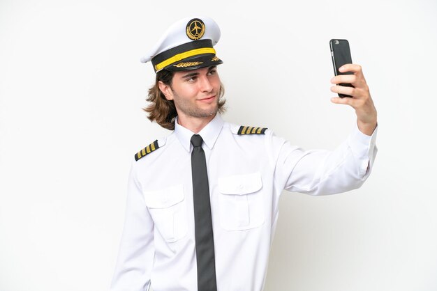 Piloto de avião bonito isolado no fundo branco fazendo uma selfie