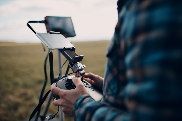 Piloto de homem controlando drone quadcopter com teclado de controle remoto.