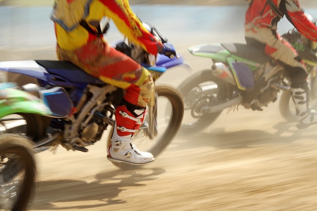Foto piloto de moto de corrida aumenta velocidade em pista de terra
