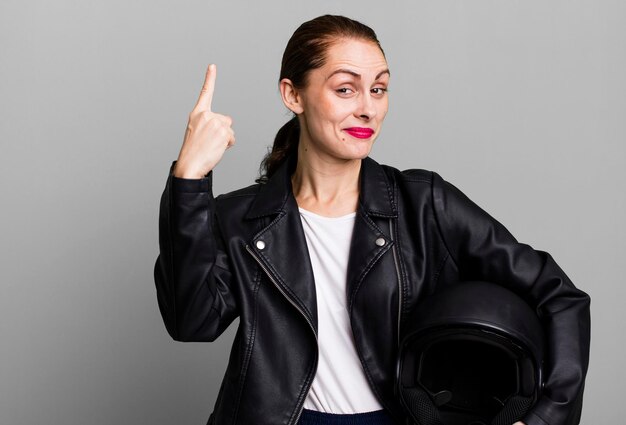 Foto piloto de moto jovem adulto bonita com jaqueta de couro e capacete