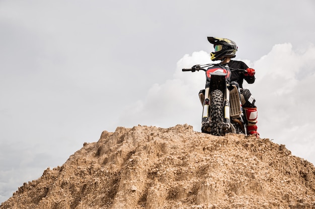 Piloto de motocross em sua bicicleta pronto para correr em pista de terra, esporte extremo e conceito de aventura de viagem.