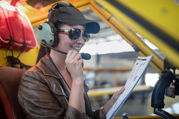 Piloto feminino inspecionando cabine de avião leve