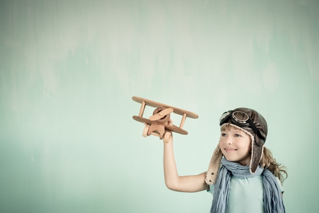 Piloto infantil. Criança brincando em casa. Liberdade e conceito de viagens. Sonho e imaginação