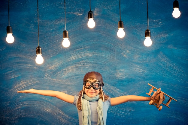 Foto piloto infantil. niño jugando en casa. concepto de libertad y viaje. sueño e imaginación