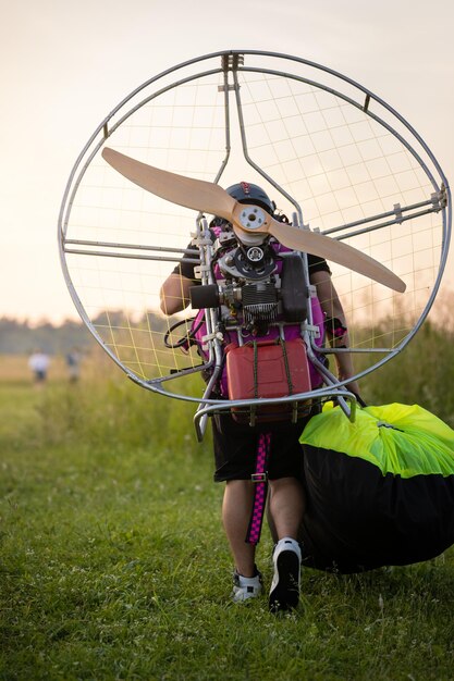 Un piloto masculino está preparando un paralet de gasolina para vuelos en parapente