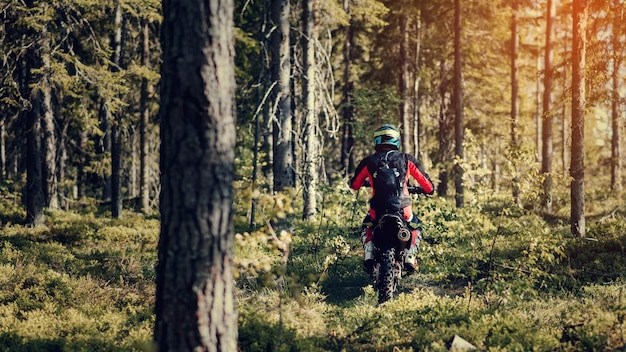 Piloto de motos en una moto deportiva de enduro paseos en el bosque en una carrera offroad