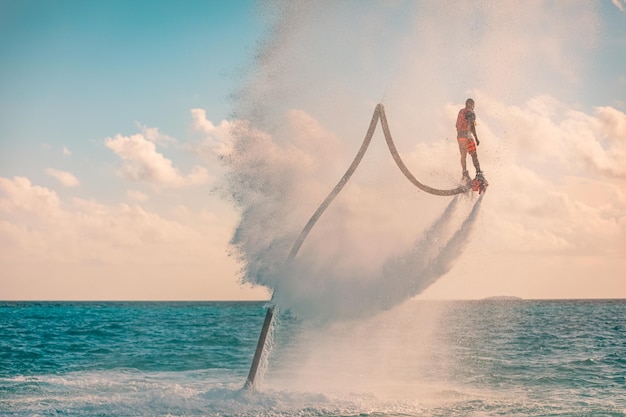 Piloto profesional de flyboard en fondo de deportes acuáticos de mar tropical Actividad deportiva al aire libre