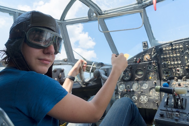 Piloto retro de chico adolescente en cabina de avión vintage antiguo