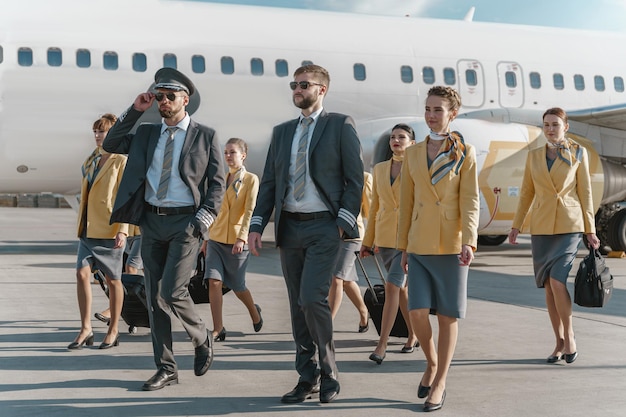 Pilotos e comissários de bordo andando pelo aeródromo após o pouso