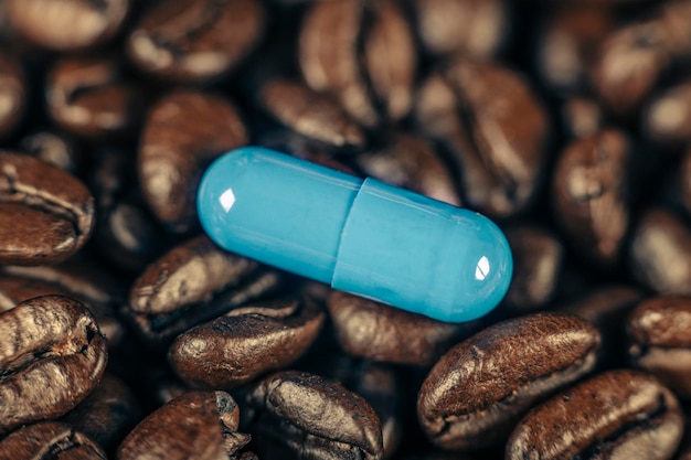 Foto pílula suplementaria de cafeína azul y granos de café tostados